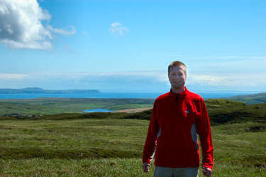 Picture of Armin on the top of a hill, open sea with a peninsula in the background
