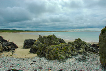 Picture of a view over a beach with rocks in the foreground