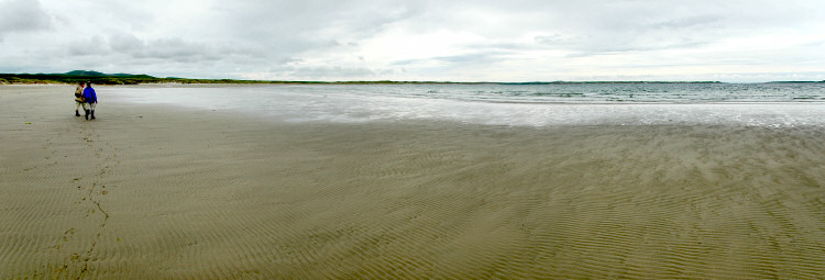 Picture of panoramic view over a wide beach with two walkers