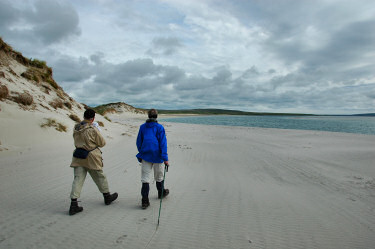 Picture of a couple walking around a bend of a beach