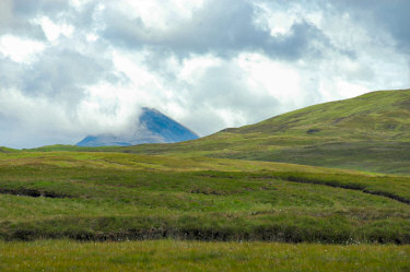 Picture of a hill surrounded by clouds