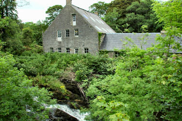 Picture of a large old building with a river running past it