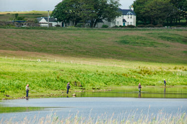 Picture of anglers standing on the shore of a loch (lake)