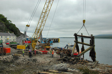 Picture of a crane lifting a part of an old pier, several girders welded together