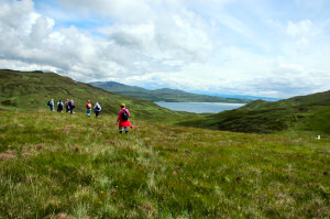 Picture of a group of walkers walking into a glen (valley)