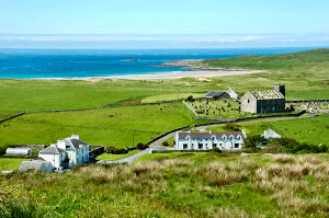 Picture of a view over Machir Bay with a sandy beach and dunes, houses in the foreground