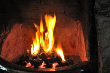Picture of an open fire in a fireplace, coal glowing red