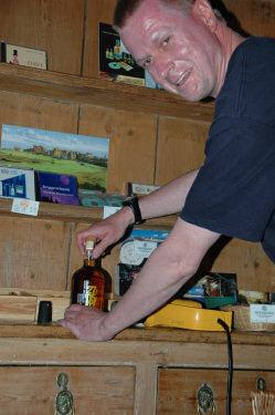 Picture of a man pushing a cork into a whisky bottle