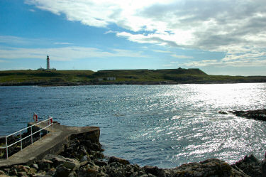 Picture of a lighthouse on an island on the other side of a small sound