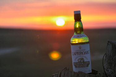 Picture of a bottle of Laphroaig Quarter Cask with a sunset in the background