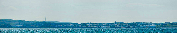 Picture of a coastal village along the shore of a sea loch, including a distillery (Bowmore)