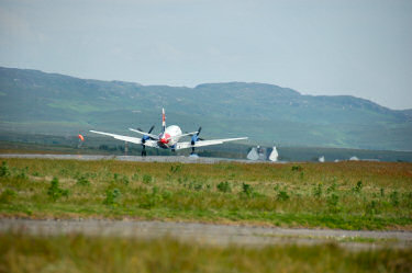 Picture of a plane touching down, smoke at one tyre