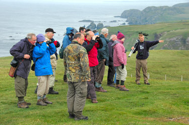 Picture of a group of walkers and birdwatchers with a guide pointing out a feature