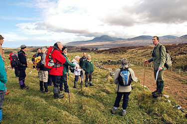 Picture of a head gamekeeper explaining a site to a group of walkers