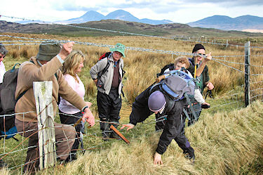 Picture of walkers climbing through a fence