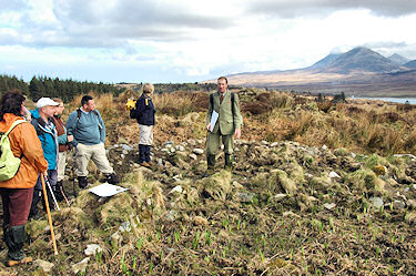 Picture of a group of walkers with a walk leader at the ruins of a building