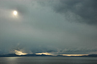 Picture of the sun breaking through clouds above the sea