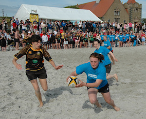 Picture of female beach rugby player about to score with a try