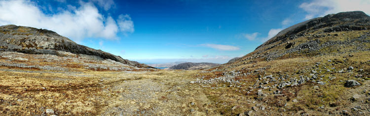 Picture of a view over a wide landscape from the saddle between two mountains