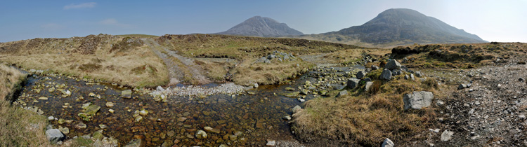 Picture of a view over a wide landscape from the saddle between two mountains