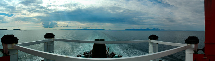 Picture of a panoramic view over the sea from a ferry with three islands visible in the distance
