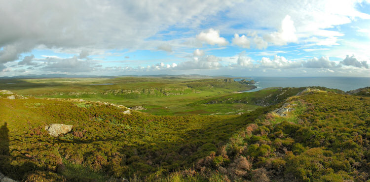 Picture of a view over a dramatic coastline, a wide glen (valley) breaking up the cliffs