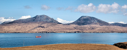 Picture of two distinctive mountains seen accross a sound between two islands