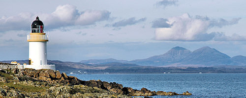 Picture of a lighthouse with some distinctly shaped hills in the background